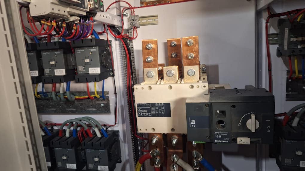 Close-up of circuit breakers, copper busbars and cable connections