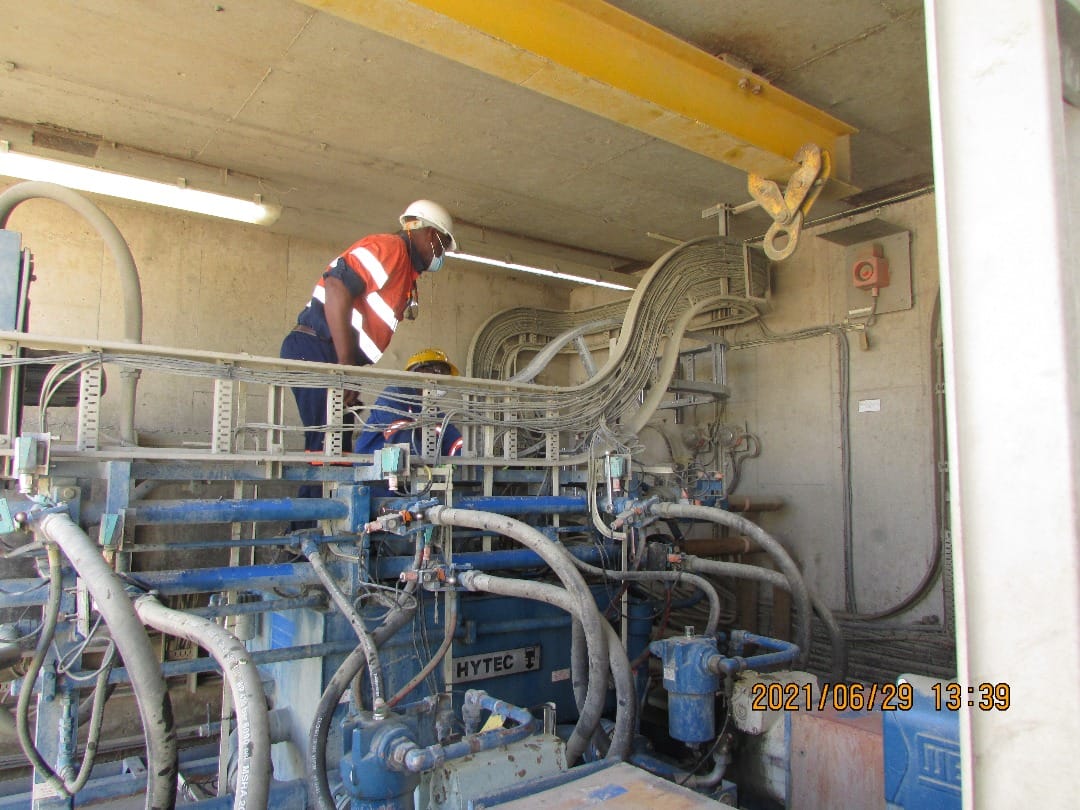 Technician inspecting industrial machinery, pipework and handwheels