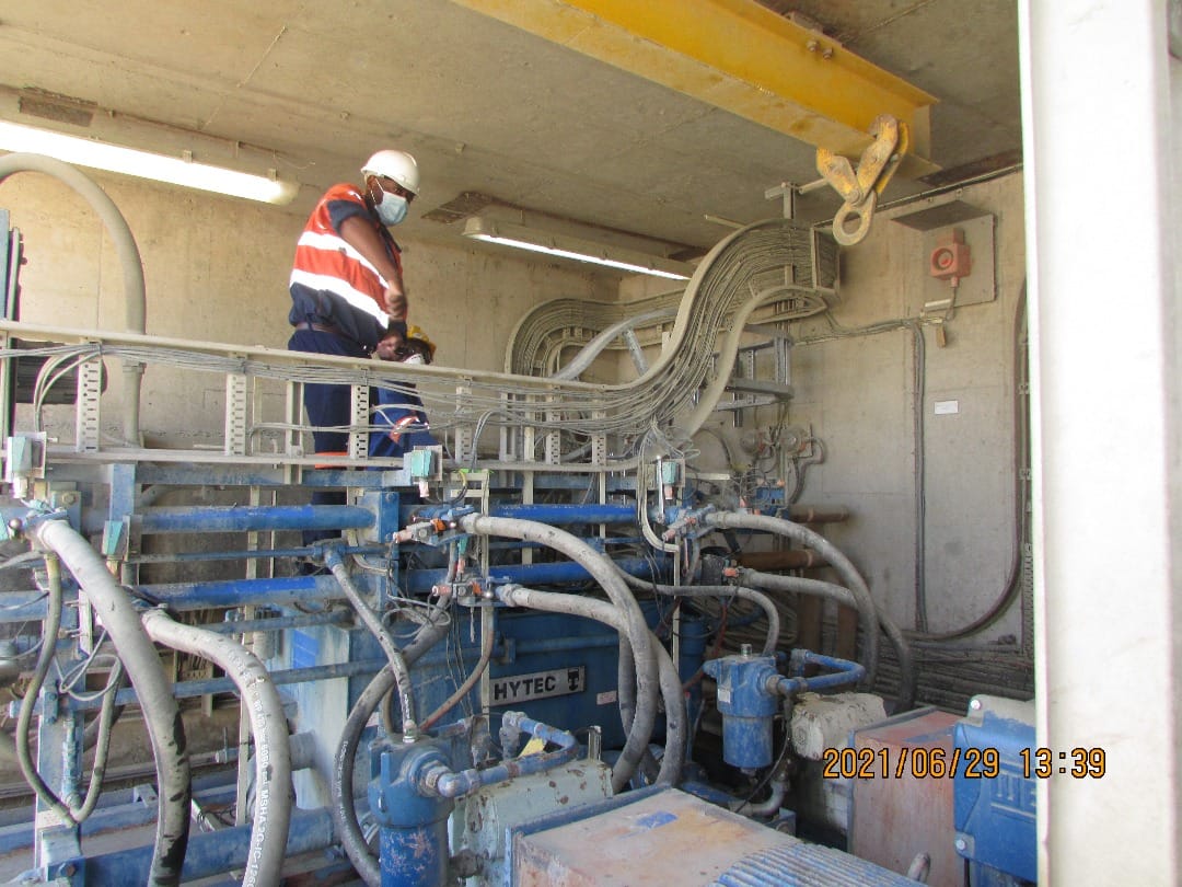 Maintenance work beside industrial equipment and pipework