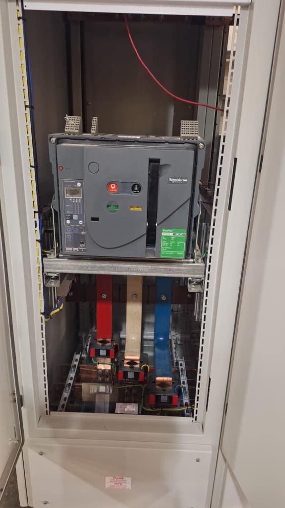 Main circuit breaker and wiring inside a tall electrical cabinet