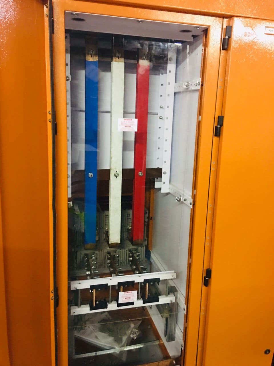 Power distribution busbars inside an orange electrical enclosure